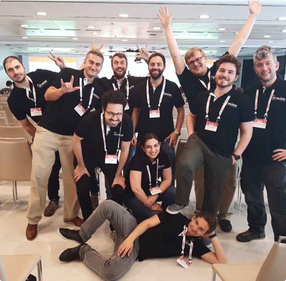 group photo of the Shadow Robot engineering team, making various Hand signals and smiling