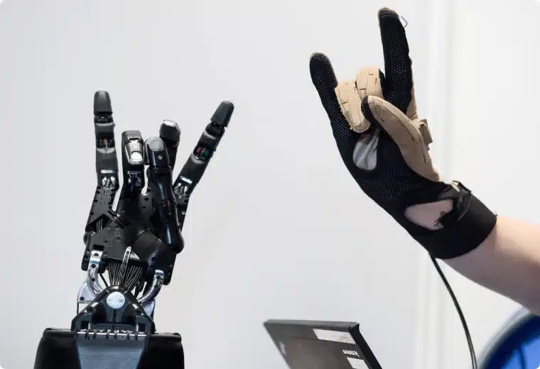 A gloved Hand and the Shadow Dexterous Hand doing a rock Hand sign 🤘